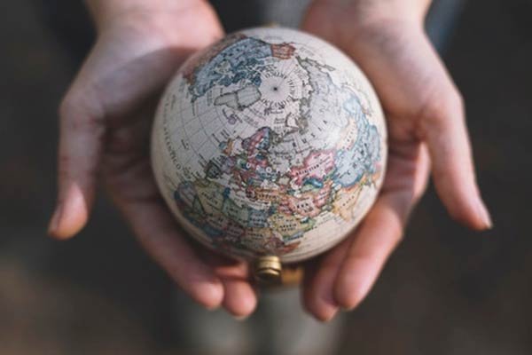 maestria en Negocios Internacionales - globo del mundo en las manos de una persona